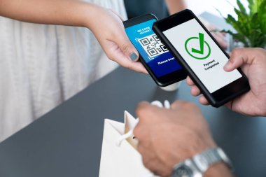 Parasız ödeme taraması için QR kodu ekranda görüntülendi. Kapalı eller, mobil uygulamadan elektronik işlem yoluyla para aktarmak için akıllı telefonu tutuyor. Hızlı ödeme için barkod teknolojisi. Coşkulu