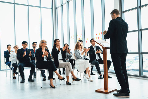 Встреча группы деловых людей на семинаре. Аудитория слушает инструктора на тренинге по обучению сотрудников. Форум сообщества офисных работников с экспертным докладчиком. Дживи