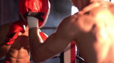 Asyalı ve Kafkasyalı Muay Thai boksörü boks antrenmanında boks antrenmanında boks antrenörüne yumruk atma, Muay Thai boks tekniği ve becerilerini sergileme. Impetus