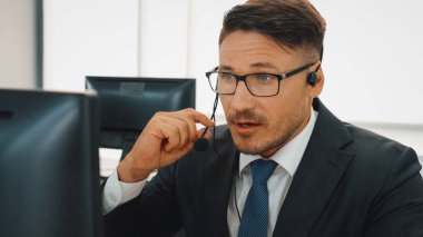 Ofiste çalışan kulaklık takan işadamları uzak müşteri ya da meslektaşlarını desteklemek için çalışıyorlar. Çağrı merkezi, tele pazarlama, müşteri destek acentesi telefon görüşmesinde hizmet sağlıyor. Jivy