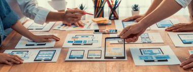 Kağıt kablo arayüzü üzerinde mobil uygulama için UI ve UX tasarımları yapan ön-uç geliştirici ekibin panorama görüntüsü. Kullanıcı dostu UI tasarımı için kullanıcı arayüzü geliştirme ekibi planlama. İnceleyin