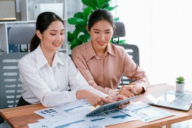 Analist ekip arkadaşı dijital gösterge panelinde finansal verileri tartışır, grafikleri dizüstü bilgisayar ve tablet ekranda analiz eder. Modern ofis pazarlama planlamak için iş zekasını kullanır. Coşkulu.