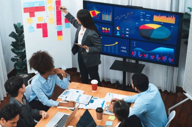 Genç Asyalı iş kadını modern toplantıda TV ekranında veri analizi paneli sunuyor. Bir grup iş adamıyla konferans odasında iş sunumu. Uyum