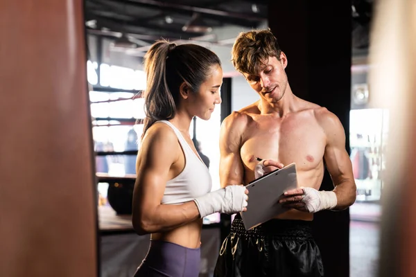 Asyalı bayan Muay Thai boksörü ve kişisel boks antrenörü spor salonundaki fiziksel ilerlemesini tartışıyor. Vücut kası gelişimine ve boks performansına bağlılığını yansıtıyor. Impetus