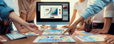 Grafik tasarımcı logo ve grafik sanatları yoğun sanat atölyesinde, dizüstü bilgisayar gösterim atölyesinde. Yaratıcı tasarım için renk paleti ve desen deneniyor. Panorama çekimi. İnceleyin