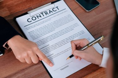 Yakın plan sözleşme imzalama belgesini kalemle imzalama, iş anlaşmasını imzayla mühürleme. İş adamları iş anlaşmasını imzalamak için sözleşmeye imza atıyorlar. Coşkulu.