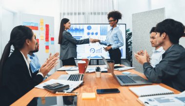 Çeşitli iş arkadaşları bunu şirket işyerinde el sıkışma ve takım çalışmasıyla kutluyor. Başarılı bir toplantıdan sonra el sıkışmayla ya da veri analizi üzerine iş sunumuyla birleşen mutlu iş adamları. Uyum