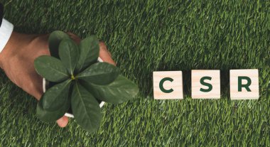 Üst düzey bir işadamı elinde CSR 'ı sembolize eden küplü bir saksı tutuyor. Karbondioksit salınımı politikası olmayan etik ve çevre dostu yeşil iş. Yeşil toplumdan sorumlu kurumsal bir sosyal sorumluluk üstlenin. Değiştir