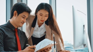 İki iş adamı toplantı odasında proje stratejisi hakkında konuşuyor. İş adamı, iş yerinde iş arkadaşlarıyla proje planlamasını tartışırken aynı zamanda mali raporla ilgili sohbet ve tavsiyelerde bulunuyor. Jivy