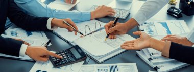 Ofiste çalışan denetçi ve muhasebeci ekibi mali verileri ve muhasebe kayıtlarını hesap makinesiyle analiz ediyor. Muhasebe şirketi kârlı nakit akışı için finansman ve vergilendirme planlaması sağlıyor. İçgörü