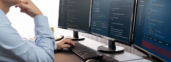 소프트웨어 엔지니어는 자신의 컴퓨터 디스플레이 코드와 스크립트를 사무실의 모니터에서 개발중이다 — 스톡 사진