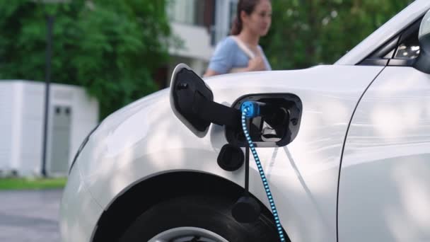 Vrouw Laad Haar Elektrische Auto Met Lader Van Smart Home — Stockvideo