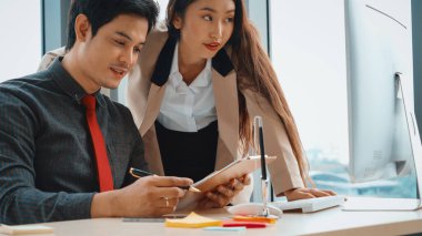 İki iş adamı toplantı odasında proje stratejisi hakkında konuşuyor. İş adamı, iş yerinde iş arkadaşlarıyla proje planlamasını tartışırken aynı zamanda mali raporla ilgili sohbet ve tavsiyelerde bulunuyor. Jivy