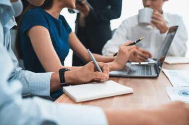 Sekreter, toplantı odasında görüşen bir grup çok ırklı iş adamıyla şirket toplantısında defterine not alıyor. Modern ofiste profesyonel toplantılarda çeşitlilik. Uyum