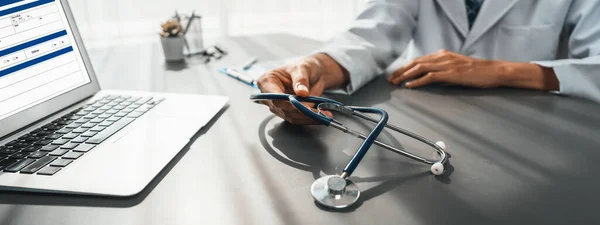 Læge Med Stetoskop Omhyggeligt Gennemgå Detaljeret Medicinsk Rapport Med Laptop - Stock-foto