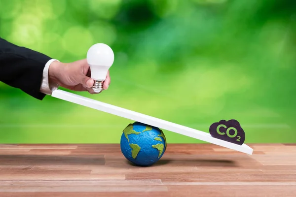 生态平衡的可持续理念相对于二氧化碳符号的重量规模 企业手握灯泡代表着Esg对绿色未来的理念 即企业对生态系统的责任 改变了 — 图库照片
