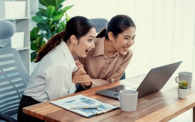 Modern ofis çalışma alanında iş birliği yapan iki genç ofis çalışanı, modern ofis çalışanı olarak profesyonelliklerini sergileyerek, dizüstü bilgisayarda tartışıyorlar ve birlikte çalışıyorlar. Coşkulu.