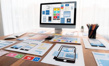 Dizüstü bilgisayar ekranında web ya da mobil uygulama UI UX için dijital ve kağıt kablo tasarımları. Beyin fırtınası ve tasarım uygulama çerçevesi için geliştirici çalışma alanının panoramik görüntüsü. İnceleyin