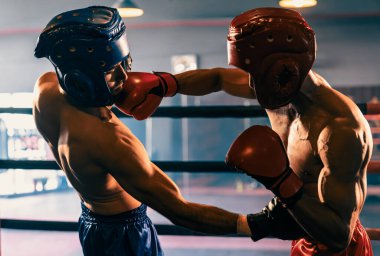 Kasklı iki atletik ve kaslı vücut boksörü ya da boks baş muhafızı vahşi bir boks maçında karşı karşıya. Boks dövüşçüsü boks ringinde dövüşüyor. Impetus