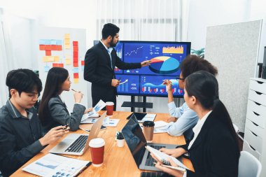 Pazarlama stratejisi için modern toplantıda veri analizi paneli ekranında sunan bir işadamı. Bir grup iş adamıyla konferans odasında iş sunumu. Uyum