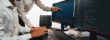 Yazılım geliştirme ekibi ofiste birlikte çalışıyor, bilgisayar ekranında betik görüntülemesi kodluyor. Teknoloji geliştirici şirketinde çalışan programcı ve yazılım mühendisi. Önde.