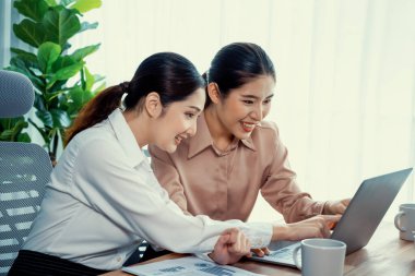 Modern ofis çalışma alanında iş birliği yapan iki genç ofis çalışanı, modern ofis çalışanı olarak profesyonelliklerini sergileyerek, dizüstü bilgisayarda tartışıyorlar ve birlikte çalışıyorlar. Coşkulu.