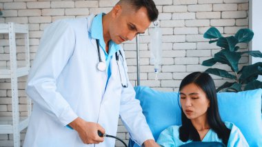 Profesyonel üniformalı doktor hastanedeki ya da klinikteki hastayı muayene ediyor. Sağlık, tıbbi ve doktor servis konsepti. Jivy