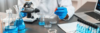 Bilimadamları tıbbi laboratuvarda kimyasal deneyler yapıyor. Aşı ilacı veya antibiyotik gelişimi için pipetten deney tüpüne kesin miktarda sıvı bırakıyor. Neoterik