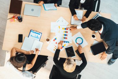 İş adamları grup toplantısı ofiste yukarıdan çekildi. İş kadınları, iş adamları ve ofis çalışanları toplantı masasında proje planlama belgeleriyle takım konferansında çalışıyorlar. Jivy