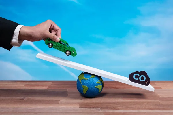 商人将环保电动车与二氧化碳符号进行了比例尺 推广了企业零排放汽车 可持续和平衡的绿色环境方法 零净排放车辆 改变了 — 图库照片