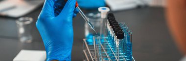 Bilimadamları tıbbi laboratuvarda kimyasal deneyler yapıyor. Aşı ilacı veya antibiyotik gelişimi için pipetten deney tüpüne kesin miktarda sıvı bırakıyor. Neoterik