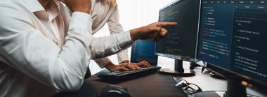 Yazılım geliştirme ekibi ofiste birlikte çalışıyor, bilgisayar ekranında betik görüntülemesi kodluyor. Teknoloji geliştirici şirketinde çalışan programcı ve yazılım mühendisi. Önde.