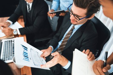 Ofis masasındaki finansal veri raporlarını analiz eden çeşitli bir grup iş analisti. Stratejik pazarlama planlaması için iş istihbarat analizine göre grafikler ve grafikler.