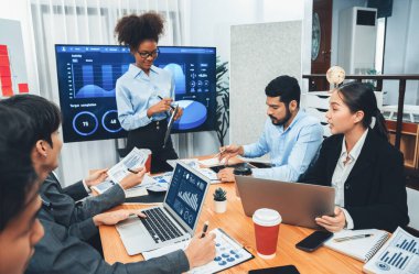 Genç Afrikalı iş kadını modern toplantıda TV ekranında veri analizi paneli sunuyor. Bir grup iş adamıyla konferans odasında iş sunumu. Uyum
