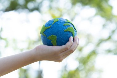 Dünya gezegenini ESG ilkesi ve çevre dostu enerjisiyle daha parlak bir gelecek için Dünya günü olarak el ele tutuşan genç çocuklar. Döngü