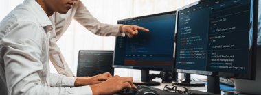 Yazılım geliştirme ekibi ofiste birlikte çalışıyor, bilgisayar ekranında betik görüntülemesi kodluyor. Teknoloji geliştirici şirketinde çalışan programcı ve yazılım mühendisi. Önde.