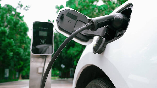 Progressive sustainability of energy concept by electric car parking and recharging next to home charging station. Electric vehicle driven by renewable energy for environmental preservation.