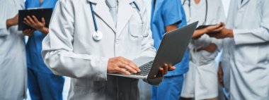 Hastanede dizüstü bilgisayar ve tabletle birlikte çalışan doktor hemşire ve sağlık uzmanlarına sahip tıbbi personel ekibi. Panoramik pankartta tıbbi işyeri ve sağlık hizmetleri topluluğu. Neoterik