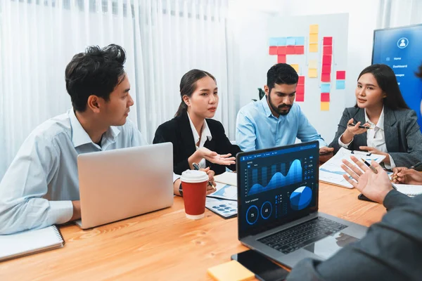 Çok ırklı analist ekibi toplantı masasındaki finansal verileri analiz etmek için BI Fintech yazılımı kullanıyor. Finansal konsol veri ekranında pazarlama göstergesi için analiz edilmiş grafikle birlikte. Uyum