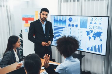 Pazarlama stratejisi için modern toplantıda veri analizi paneli ekranında sunan bir işadamı. Bir grup iş adamıyla konferans odasında iş sunumu. Uyum