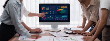 Analist ekibi, FBI Fintech 'i kullanarak mali konsolu inceliyor ve işaret ediyor. İş adamları iş görüşü için raporları inceliyor. Panorama çekimi. İnceleyin