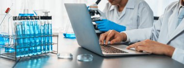 Kendini adamış bir grup bilim adamı tıbbi laboratuvarda kimyasal deneyler ve araştırmalar yaparak yeni aşı ilacı veya antibiyotik için çığır açan gelişmeler gerçekleştiriyor ve laptopta test sonuçları üzerinde çalışıyorlar. Neoterik