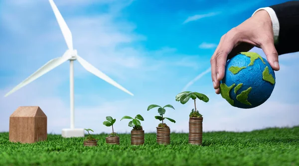 エコビジネスは 環境保全補助金 成長苗付きコインスタック 紙地球と風力タービンを保持する手に投資します クリーンで再生可能なエネルギーによる持続可能な金融成長 Alter — ストック写真