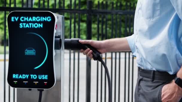 사업가는 충전소에서 충전기를 주차장에서 자동차를 충전합니다 Co2 Peruse를 감소시키는 생활양식 — 비디오