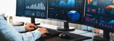 Analizci veri analizi ya da bilgisayar monitöründeki BI gösterge paneli üzerinde çalışıyor. Ticari pazarlama ve strateji planlaması için Fintech 'in şirket ofisindeki finansal verilerini analiz eden bir işadamı. Önde.