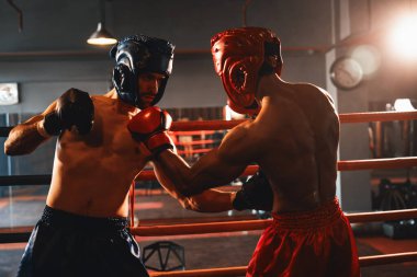 Kasklı iki atletik ve kaslı vücut boksörü ya da boks baş muhafızı vahşi bir boks maçında karşı karşıya. Boks dövüşçüsü boks ringinde dövüşüyor. Impetus