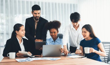 Çok ırklı analist ekibi toplantı masasındaki mali raporu analiz etmek için BI gösterge tablosunu kullanıyor. Çeşitli iş adamlarından oluşan bir grup, FIntech 'in veri analizini başarılı iş pazarlaması için kullanır. Uyum
