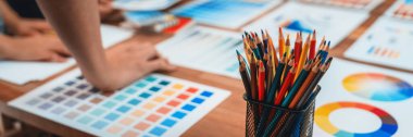 Grafik tasarımcı beyin fırtınası logosu ve grafik sanat yoğun yaratıcı stüdyo atölyesinde. Yaratıcı tasarım için çalışma masasında deney ve beyin fırtınası renk paleti ve desen. Panorama çekimi. İnceleyin