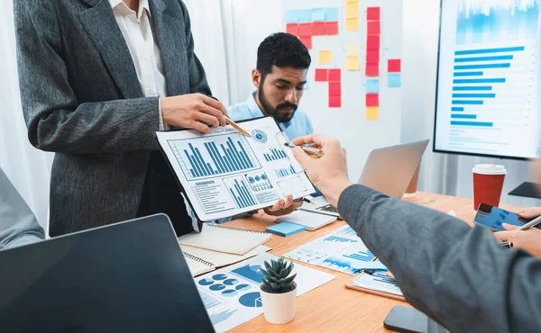 stock image Analyst team use BI dashboard data to analyze financial report on meeting table. Group of diverse business people utilize data analysis by FIntech for business marketing decision. Concord