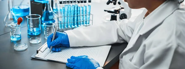 在医学实验室进行疫苗药物或抗生素的化学实验后 封闭手记录临床结果 科学化学实验室和医学研究的概念 新时代 — 图库照片